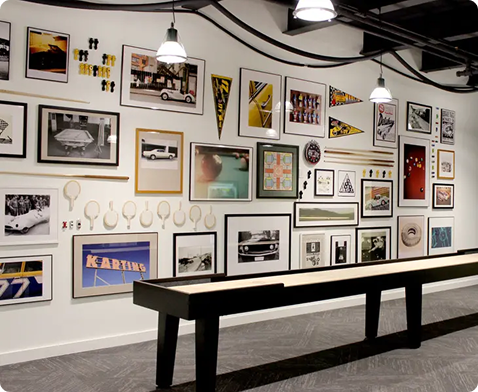 Shuffleboard table in front of a wall lined with pictures