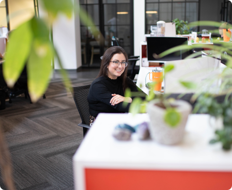 An employee smiling sitting at the work desk